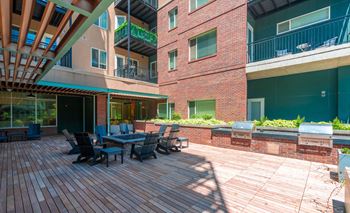 a large patio with a table and chairs outside of an apartment building